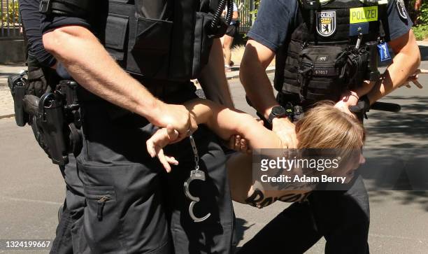 An activist from the group Femen is arrested by police officers in front of the Iranian embassy as she protests against presidential elections being...