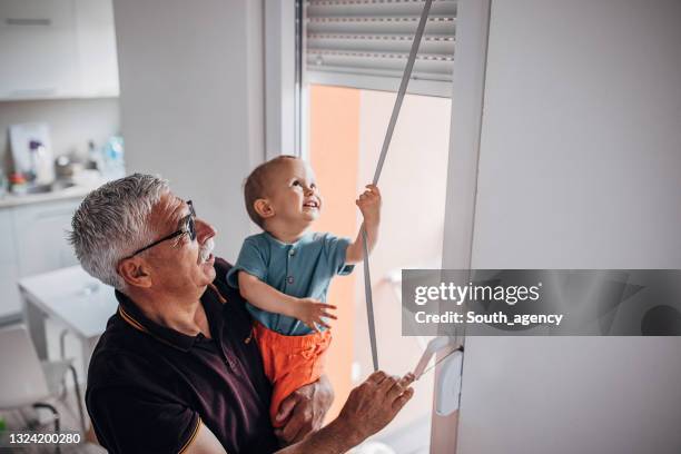 grandfather holding grandson - lameller bildbanksfoton och bilder