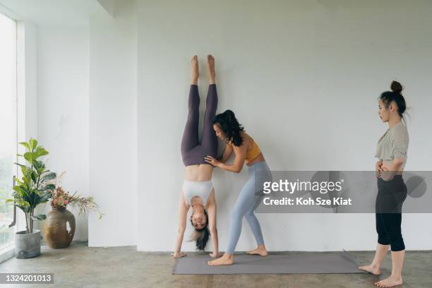 trois femmes asiatiques s’entraînant pour le handstand parfait - équilibre sur les mains photos et images de collection