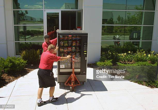 Webvan distribution center employees carry out a vending machine from the Webvan Group Inc. July10, 2001 in Carol Stream, IL. Webvan Group Inc. The...