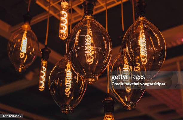 close-up of illuminated pendant lights hanging from ceiling - pendant light stockfoto's en -beelden