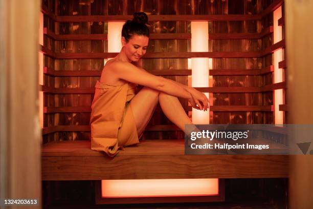 happy mid adult woman in sauna, relaxing. - sauna ストックフォトと画像