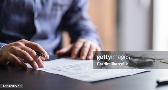 Mann füllt das Steuerformular aus Mann füllt das Steuerformular aus