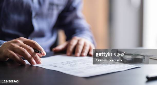 man filling in the tax form - calculator tax forms stockfoto's en -beelden