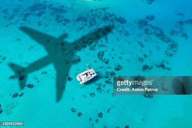 aerial view of a catamaran yacht in the blue sea. yachting, luxury vacation at sea. - sunset over beach stock pictures, royalty-free photos & images