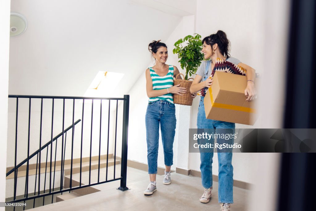 Sœurs jumelles transportant leurs affaires dans un nouvel appartement