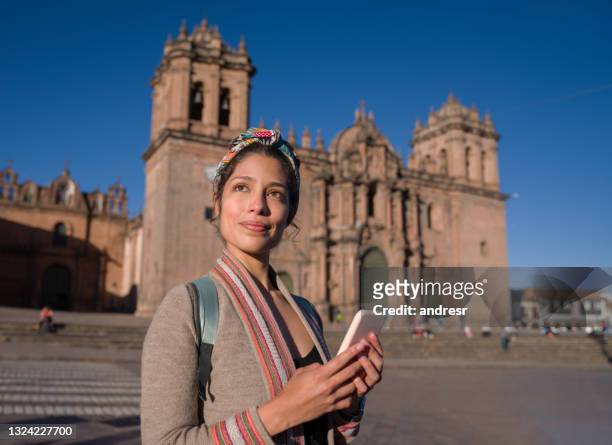 femme faisant le tour de cusco tout en en enrant un texto sur son téléphone portable - femme perou photos et images de collection