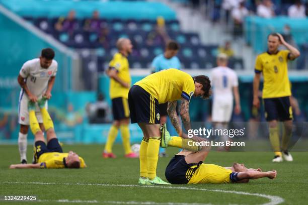 Sebastian Larsson of Sweden is helped by team mate Victor Lindeloef during the UEFA Euro 2020 Championship Group E match between Sweden and Slovakia...