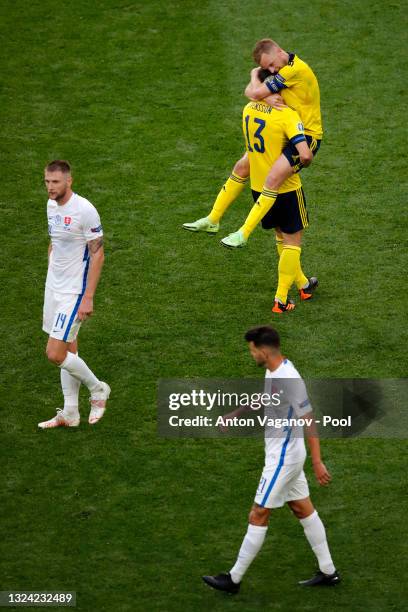 Sebastian Larsson of Sweden jumps on team mate Gustav Svensson as they celebrate their side's victory after the UEFA Euro 2020 Championship Group E...