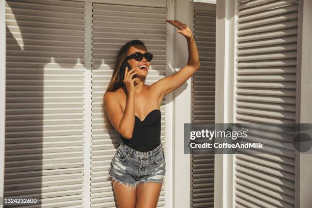 hermosa mujer feliz en la playa con teléfono inteligente - mujer seductora fotografías e imágenes de stock