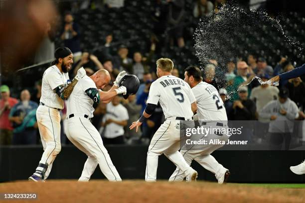 Kyle Seager of the Seattle Mariners is mobbed by teammates after a walk-off single RBI to win the game against the Tampa Bay Rays at T-Mobile Park on...