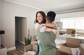 Shot of a couple looking cheerful while moving into their new home