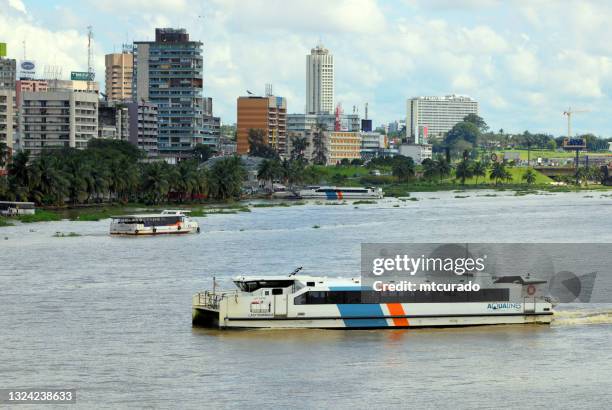 ferry-boat on the ébrié lagoon and downtown abidjan skyline, ivory coast - ivory coast town bildbanksfoton och bilder