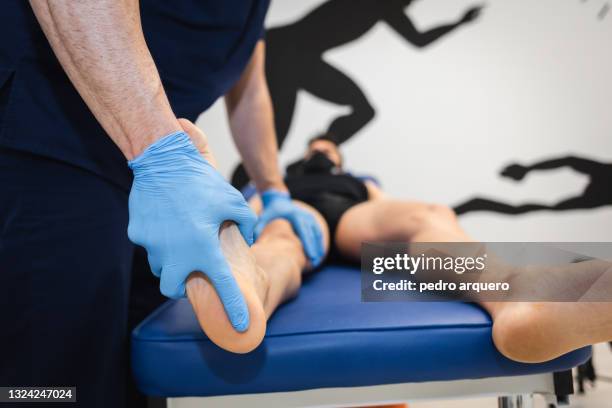 podiatrist checking the foot of a patient on a stretcher - podiatrist stockfoto's en -beelden