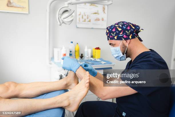 podiatrist cutting toenails and checking their condition - fußpflege stock-fotos und bilder