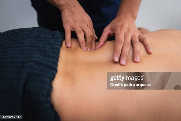 chiropractor treating a patient's back - man touching shoulder imagens e fotografias de stock