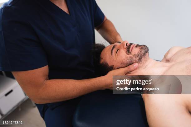 chiropractor performing an adjustment on a patient's neck - osteópata fotografías e imágenes de stock