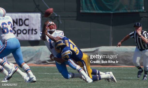 Houston Oilers QB Warren Moon gets hit as he releases a pass during playoff game action against Houston Oilers, September 30, 1990 in San Diego,...