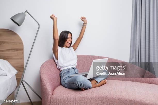 joyful woman celebrating success while working on laptop - laptop netbook fotografías e imágenes de stock