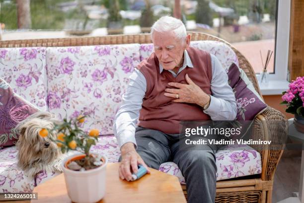 emergency situation of a senior man having asthma attack - chronic obstructive pulmonary disease stockfoto's en -beelden