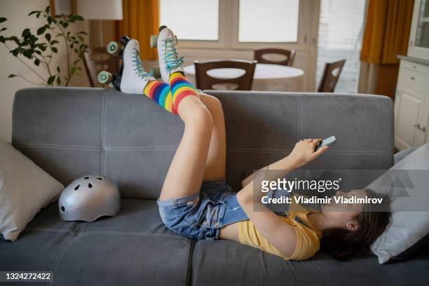 ein teenager, der mit den beinen auf dem rücken eines sofas ruht - lying on back girl on the sofa stock-fotos und bilder
