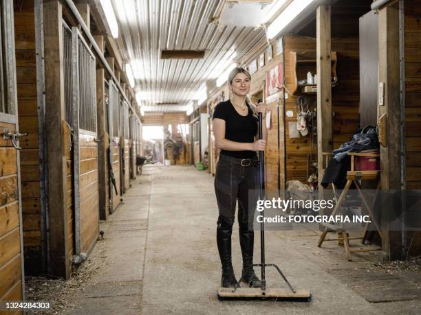 young female trainer doing chores - holding broom stock pictures, royalty-free photos & images