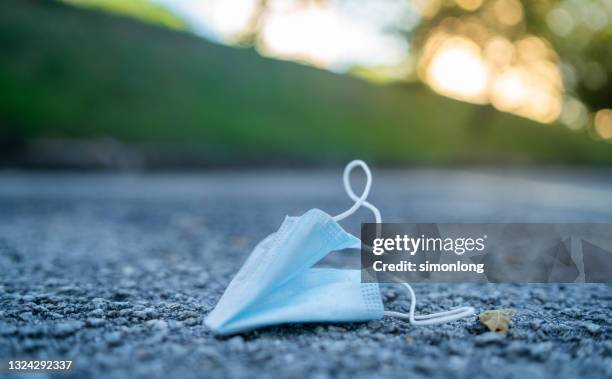 blue face mask on the ground - lower foto e immagini stock