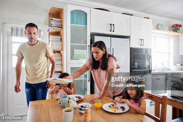 shot of a happy young family having breakfast together at home - busy kitchen stock pictures, royalty-free photos & images