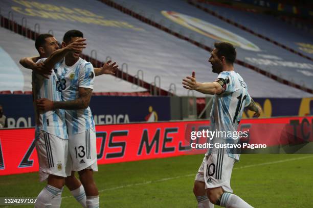 Guido Rodriguez of Argentina celebrates with teammates Cristian Romero and Lionel Messi after scoring the first goal of his team during a group A...