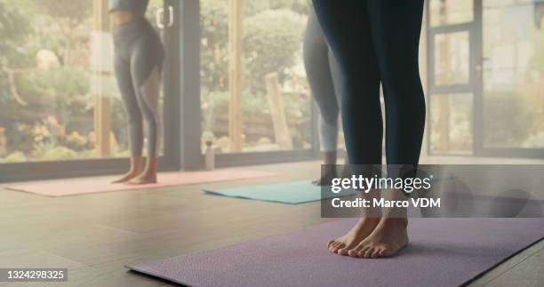 shot of a group of women practicing yoga in a fitness class - mat stockfoto's en -beelden