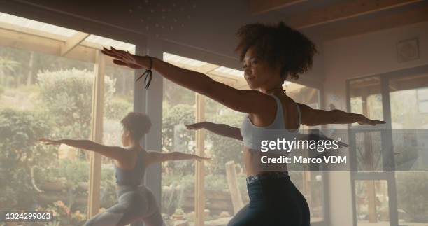 shot of a group of young women practicing yoga in a fitness class - toughness imagens e fotografias de stock