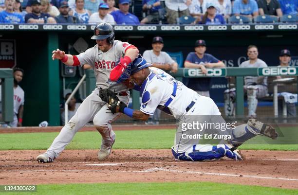 Christian Arroyo of the Boston Red Sox is tagged out by Salvador Perez of the Kansas City Royals on a fielder's choice in the third inning at...