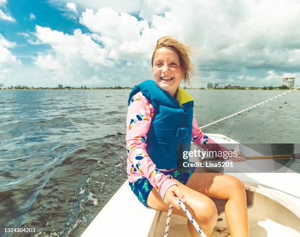 happy young summer camp girl sailing a small sailboat on a scenic summer lake - sunfish 個照片及圖片檔