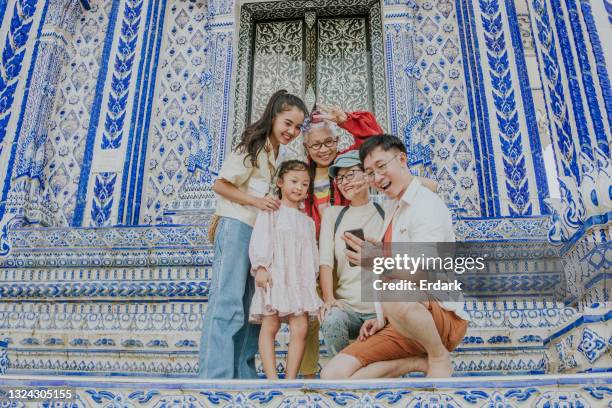 big thai family are taking a selfie with a beautiful old architecture on their weekend trip-stock photo - tourist mother father child thailand stock pictures, royalty-free photos & images