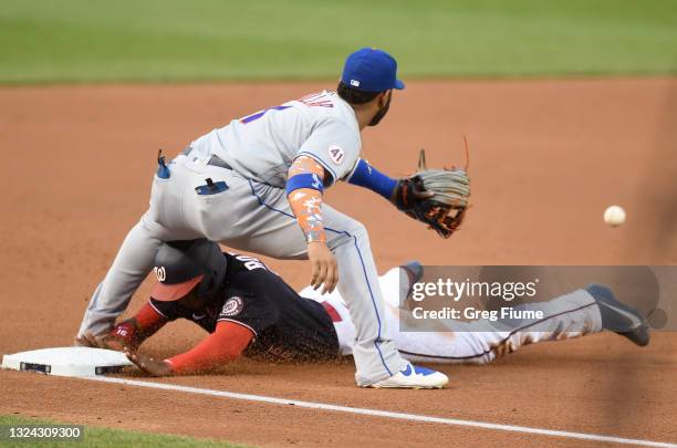 Victor Robles of the Washington Nationals slides into third base ahead of the throw to Jonathan Villar of the New York Mets in the third inning at...