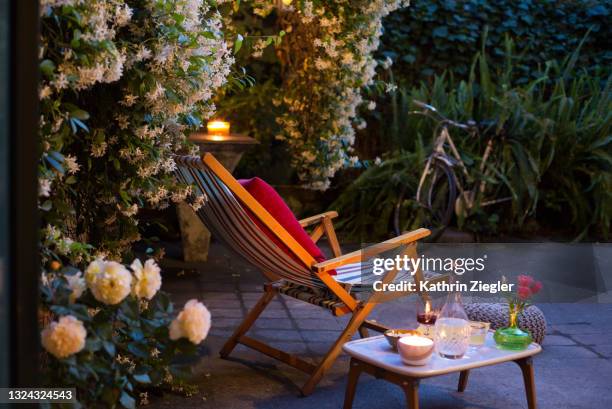 deck chair in back yard with drinks and snacks on side table - backyard deck stockfoto's en -beelden