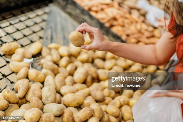 femme achetant des pommes de terre crues au supermarché - pomme de terre photos et images de collection