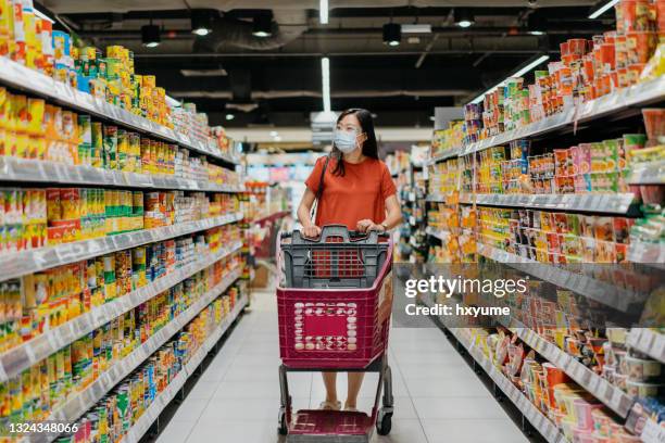 femme asiatique avec masque facial et écran facial magasinant pour l’épicerie au supermarché - ready meal photos et images de collection