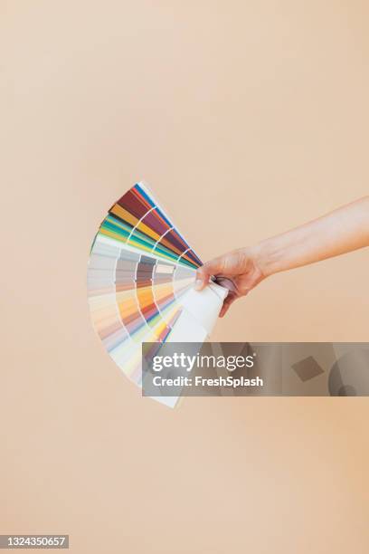 woman's hand holding color swatches book - artist palette stock pictures, royalty-free photos & images