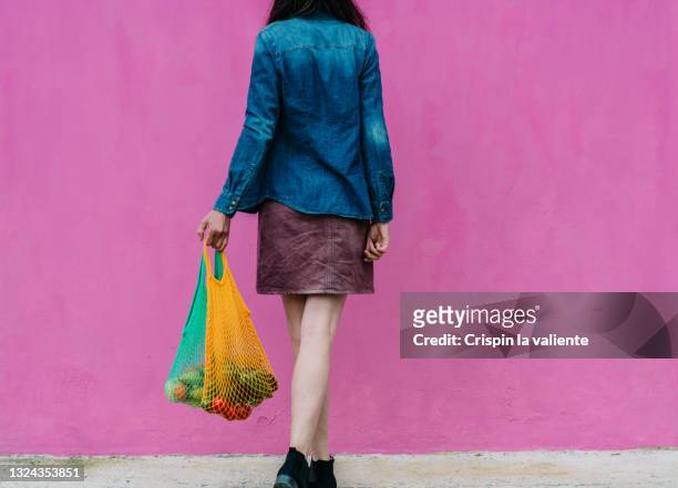 back view of woman body carrying two reusable bags with sustainable purchase - reusable bag stock pictures, royalty-free photos & images