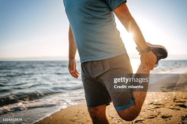 man warming up before his run - man 45 stock pictures, royalty-free photos & images