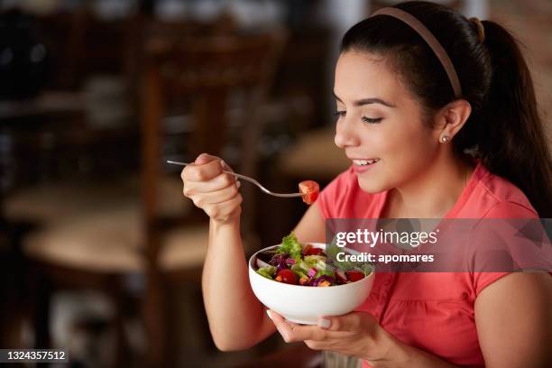 close-up de uma mulher hispânica bonita jovem comendo salada vegana no almoço - fibra - fotografias e filmes do acervo