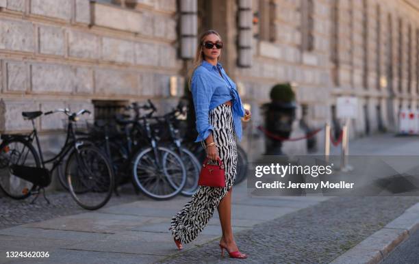 Nina Suess wearing red Lanvin shades, blue Zara shirt, black and white Jacquemus skirt, red Bottega Veneta heels and red Louis Vuitton leather bag on...