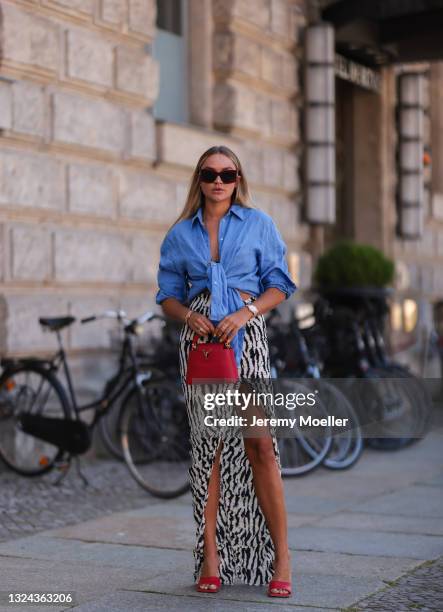 Nina Suess wearing red Lanvin shades, blue Zara shirt, black and white Jacquemus skirt, red Bottega Veneta heels and red Louis Vuitton leather bag on...