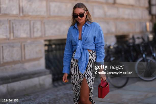 Nina Suess wearing red Lanvin shades, blue Zara shirt, black and white Jacquemus skirt and red Louis Vuitton leather bag on June 16, 2021 in Berlin,...