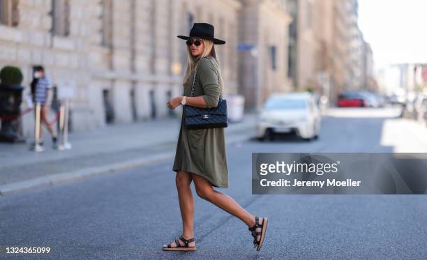Nina Suess wearing black Chanel leather flap bag and black sandals, khaki Zara dress, black Lack of Colors hat and black Dior shades on June 16, 2021...