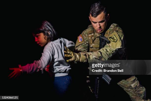 Member of the National Guard helps a child after she crossed the Rio Grande, with her family, into the U.S. On June 19, 2021 in Roma, Texas. A surge...