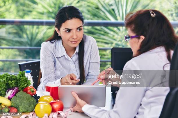 nutrition dieting concepts. nutritionist giving consultation to patient with healthy fruit and vegetable - nutritionist stock pictures, royalty-free photos & images