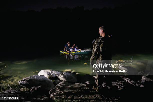 Member of the National Guard shines a flashlight on immigrants crossing the Rio Grande into the U.S. On June 19, 2021 in Roma, Texas. A surge of...