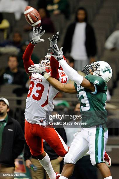 Patrick Edwards of the University of Houston Cougars catches a pass over Derrick Strozier of the Tulane Green Wave during a game being held at the...